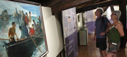 Unos visitantes observan los paneles de la exposición 'Galerna 1912-2012' en el Museo del Pescador. 