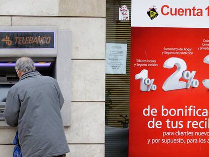 Una persona saca dinero de un cajero automático, en Madrid.