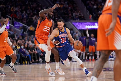Stephen Curry finta sobre Deandre Ayton en el partido entre Golden State y Phoenix.
