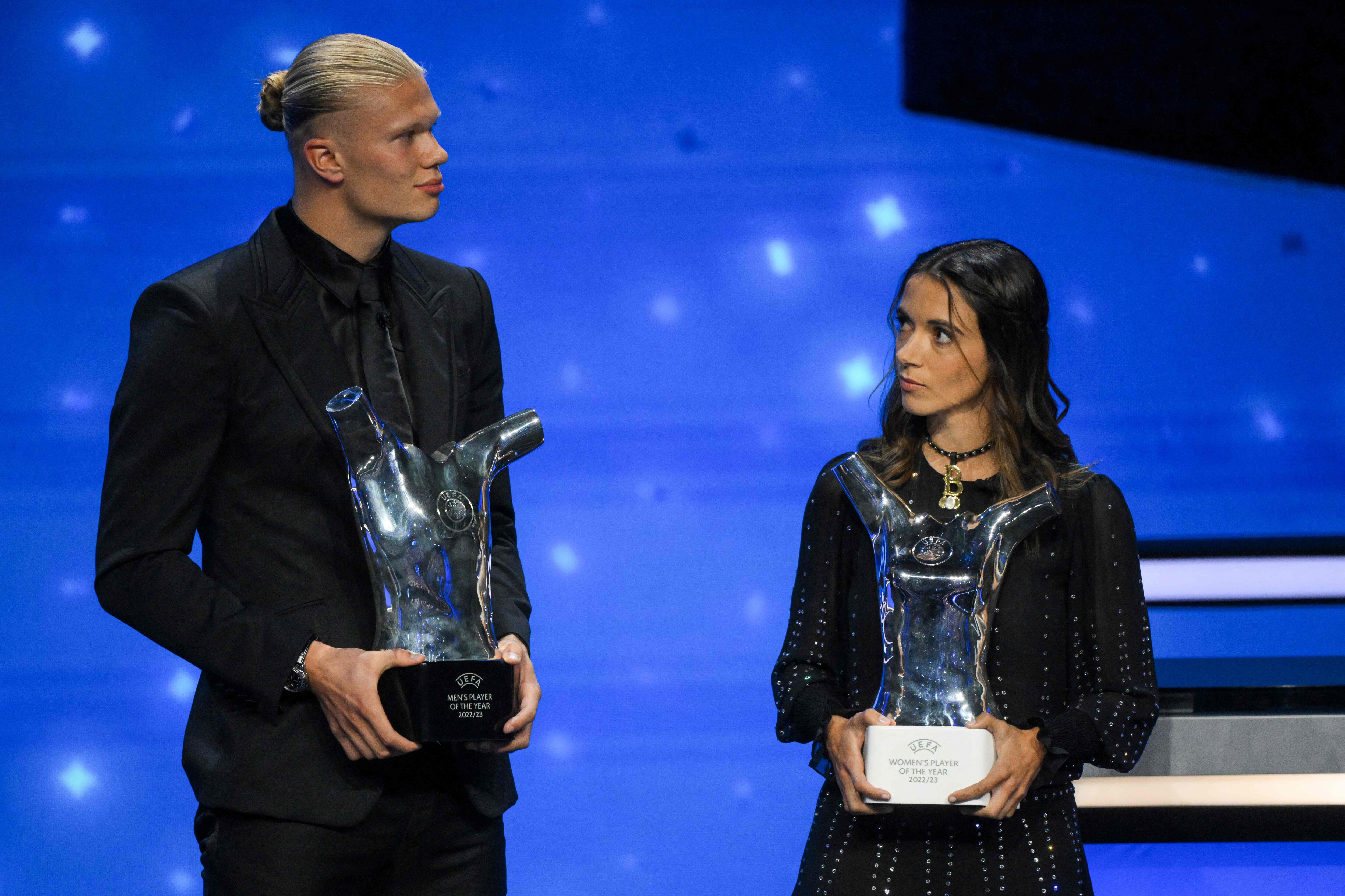 Manchester City's Norwegian striker Erling Haaland (L) and FC Barcelona's Spanish midfielder Aitana Bonmati (R) pose with their season 2022/2023 men's and women's player of the year awards during the UEFA Champions League group stage draw ceremony at The Grimaldi Forum in the Principality of Monaco, on August 31, 2023. (Photo by NICOLAS TUCAT / AFP)