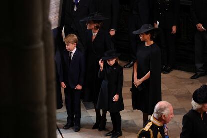 Los príncipes Jorge y Carlota, delante de su madre Kate Middleton y su tía, Meghan Markle, esperan la entrada del féretro de la reina Isabel en la abadía de Westminster .