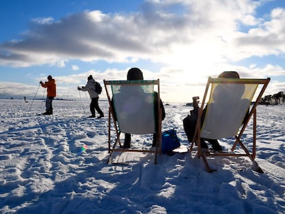 Dos personas toman el sol en Helsinki el pasado 14 de febrero. Finlandia es el país que ocupa el primer puesto en la clasificación del Informe Mundial sobre la Felicidad.