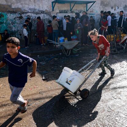 Un grupo de palestinos llenan garrafas de agua en Rafah, al sur de la franja de Gaza, este lunes.