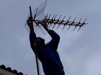 Una operario ajusta la antena en un tejado de Colmenar Viejo (Madrid).