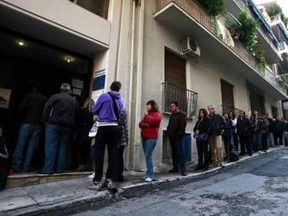 Desemplados hacen cola en una oficina del Servicio Nacional de Empleo para recoger cheques de ayuda, en Atenas.