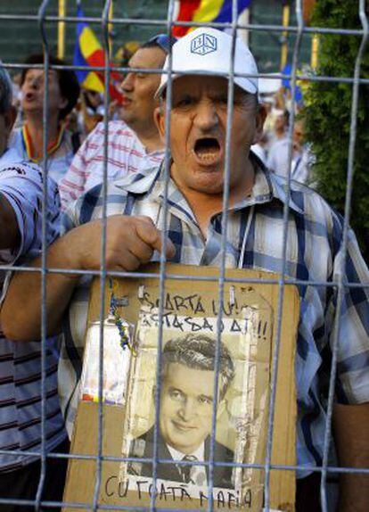 Un ciudadano protesta en Bucarest exhibiendo un retrato del dictador Ceausescu.