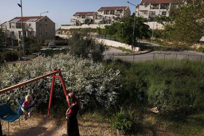 Un colono israel&iacute; juega con su hijo en el parque construido en asentamiento ilegal de Ulpana, adyacente a Beit El, cerca de la ciudad palestina de Ramala.