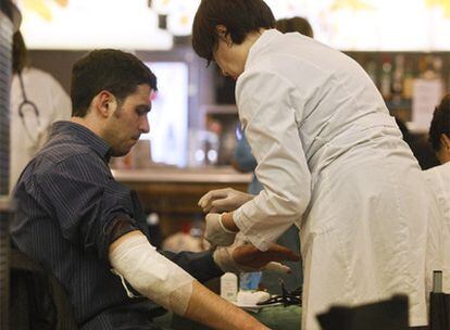 Un miembro del personal sanitario de emergencia atiende a uno de los heridos.