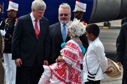 El primer ministro de Caanadá, Stephen Harper (i) recibe una calurosa bienvenida por parte de dos jóvenes panameños vestidos con trajes típicos del país.