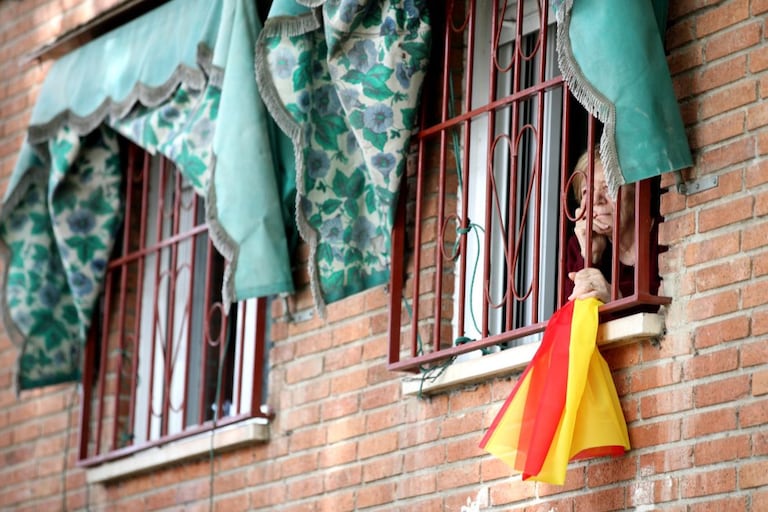 Una mujer mira por la ventana durante la detención por el coronavirus en Madrid.