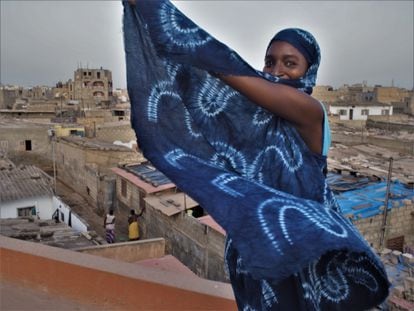 Una de las socias de la cooperativa GIE Solidaire de Confection et Artisanat del barrio de Sam Sam III en Pikine, Senegal, muestra una de las telas teñidas con índigo que ha elaborado junto a sus compañeras. Ellas se han empeñado en recuperar las técnicas tradicionales de este arte ancestral.