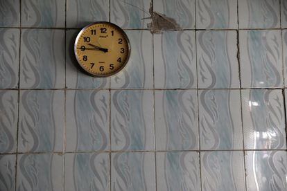 Un reloj colgado en una pared de un restaurante abandonado.