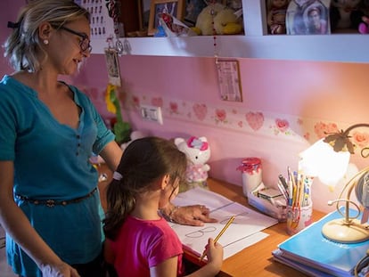 Almudena, de cinco años, rellena las fichas con las letras del abecedario con la ayuda de su madre.