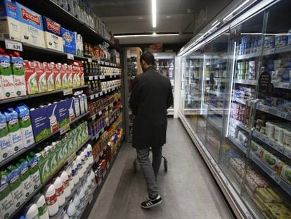 Un consumidor en la línea de productos lácteos de un supermercado en Madrid.
