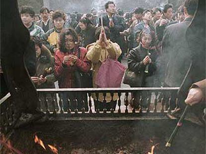 Un grupo de chinos ora y quema incienso en un templo de Pekín con motivo del nuevo año lunar.