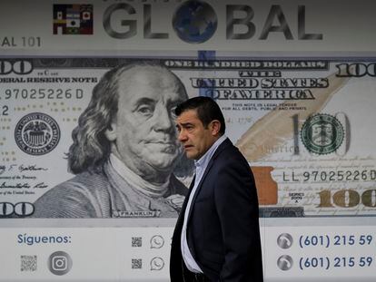 Un hombre se para frente a una agencia de cambio de moneda en Bogotá, en junio de 2022.