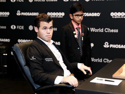 Magnus Carlsen, segundos antes de iniciar la 7ª partida, junto al niño prodigio Shreyas Royal, de 9 años, encargado del saque de honor