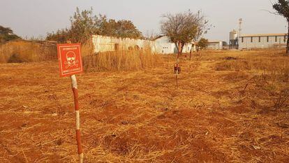 Uno de los terrenos visitados por las investigadoras en Angola, en el que aún se avisa de la presencia de explosivos.