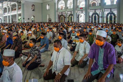 Devotos musulmanes asisten al rezo obligatorio del viernes en una mezquita de Surabaya (Indonesia).