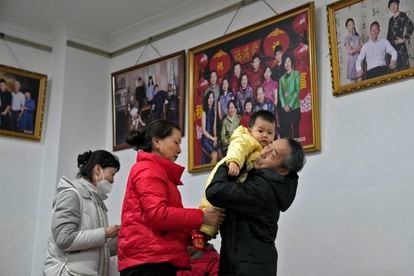 Un abuelo sujeta a su nieto después de hacerse unas fotos con los miembros de su familia, en un estudio de Pekín (China), este martes.