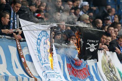 Unos aficionados del Rostock prenden fuego a una bandera del Sankt Pauli.