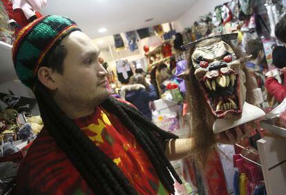 Un empleado de una tienda de disfraces donostiarra sostiene una máscara.