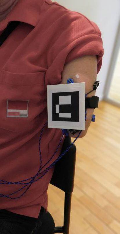 Un marcador de referencia permitió integrar realidad y realidad aumentada. Detrás, lso electrodos que registraban la actividad muscular.