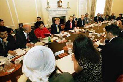 Tony Blair, flanqueado por los líderes opositores, Charles Kennedy y Michael Howard, ayer durante la reunión con representantes musulmanes.