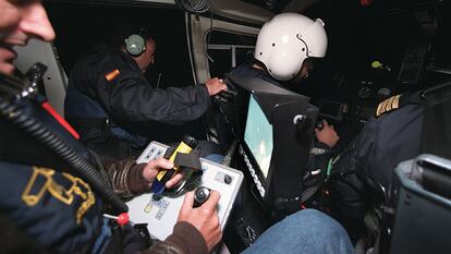 Interior de uno de los helicópteros del SVA durante una "noche de caza" en el Estrecho del Servicio de Vigilancia Aduanera de Algeciras (Cádiz) con participación del escritor Arturo Pérez Reverte con motivo de la publicación de su novela "La reina del sur". En el centro de la imagen, asomado al exterior del helicóptero, José Luis Domínguez Iborra. FOTO: RICARDO GUTIÉRREZ