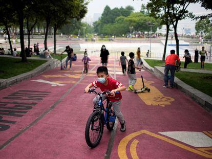 A boy wearing a face mask rides a bicycle at a riverside park, after the lockdown placed to curb the coronavirus disease (COVID-19) outbreak was lifted in Shanghai, China June 1, 2022. REUTERS/Aly Song
