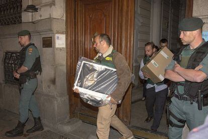 La Guardia Civil saca un ordenador del despacho de Ignacio González tras ser detenido.