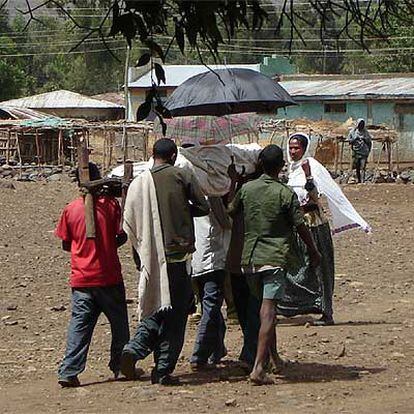 Un grupo de personas lleva a un familiar en camilla al centro de salud de Addis Zemen.