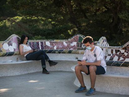 Dos personas descansan en el Park Güell. 