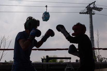 Dos vecinos practican boxeo, en un parque cercano a una de las estaciones del cablebús. 