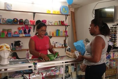 Adda Yanett Pandales Salas atiende a una cliente en su bazar, en Nuquí, Chocó.