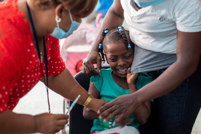 Una niña se prepara para recibir una dosis de la vacuna contra la covid-19, en Santo Domingo (República Dominicana).