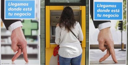 Una joven utiliza un cajero automático en una oficina bancaria, en Madrid.
