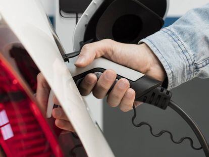 Un usuario conecta un coche eléctrico al punto de recarga.