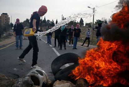 Un manifestante palestino prende fuego a las llantas mientras construían una barricada durante los enfrentamientos con las fuerzas de seguridad israelíes en el puesto de control de Atarot en las afueras del norte de Jerusalén.