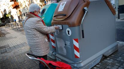 Una vecina de Sant Andreu abre uno de los nuevos contenedores inteligentes para basura orgánica.