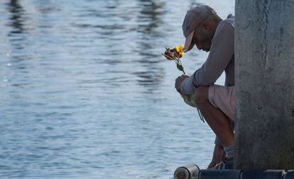 Un antiguo empleado de Truth Aquatics deposita flores en el mar en el puerto de Santa Bárbara.