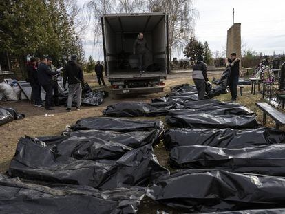Trabajadores del cementerio introducen en un camión los cadáveres de civiles asesinados en la ciudad ucrania de Bucha, el pasado 6 de abril.