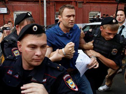 La policía detiene al líder de la oposición rusa, Alexéi Navalni, después de visitar la oficina de la comisión electoral de la ciudad para presentar documentos para registrarse como candidato a la alcaldía, en Moscú el 10 de julio de 2013.