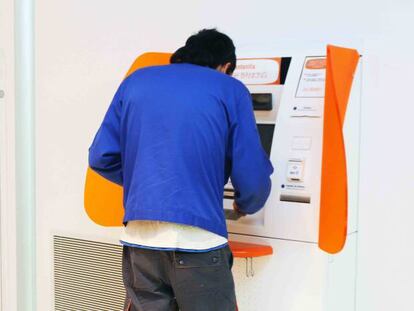 Una persona saca dinero de un cajero en una oficina de ING.