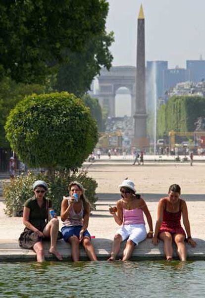 Unos turistas se refrescan en una fuente de las Tullerías, en París.