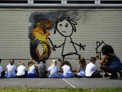 El cotizado grafitero pinta una niña con un neumático en llamas en el colegio que puso su nombre a un edificio