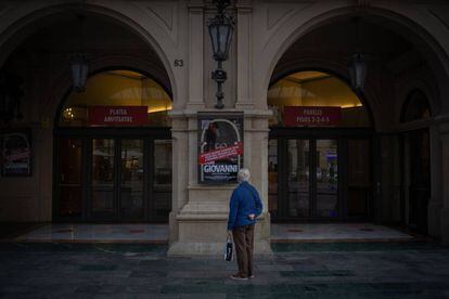 Un home mira el cartell de l'òpera 'Don Giovanni' a la porta del Liceu, amb les funcions cancel·lades per les restriccions decretades per la Generalitat.