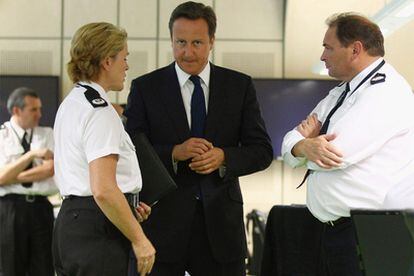 El primero ministro británico, David Cameron, entre el jefe de la policía de Birmingham, Chris Sims (derecha), y su ayudante, Sharon Rowe, el pasado día 10.