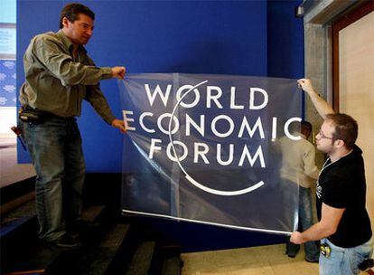 Dos operarios ultiman los preparativos de la Cumbre de Davos.