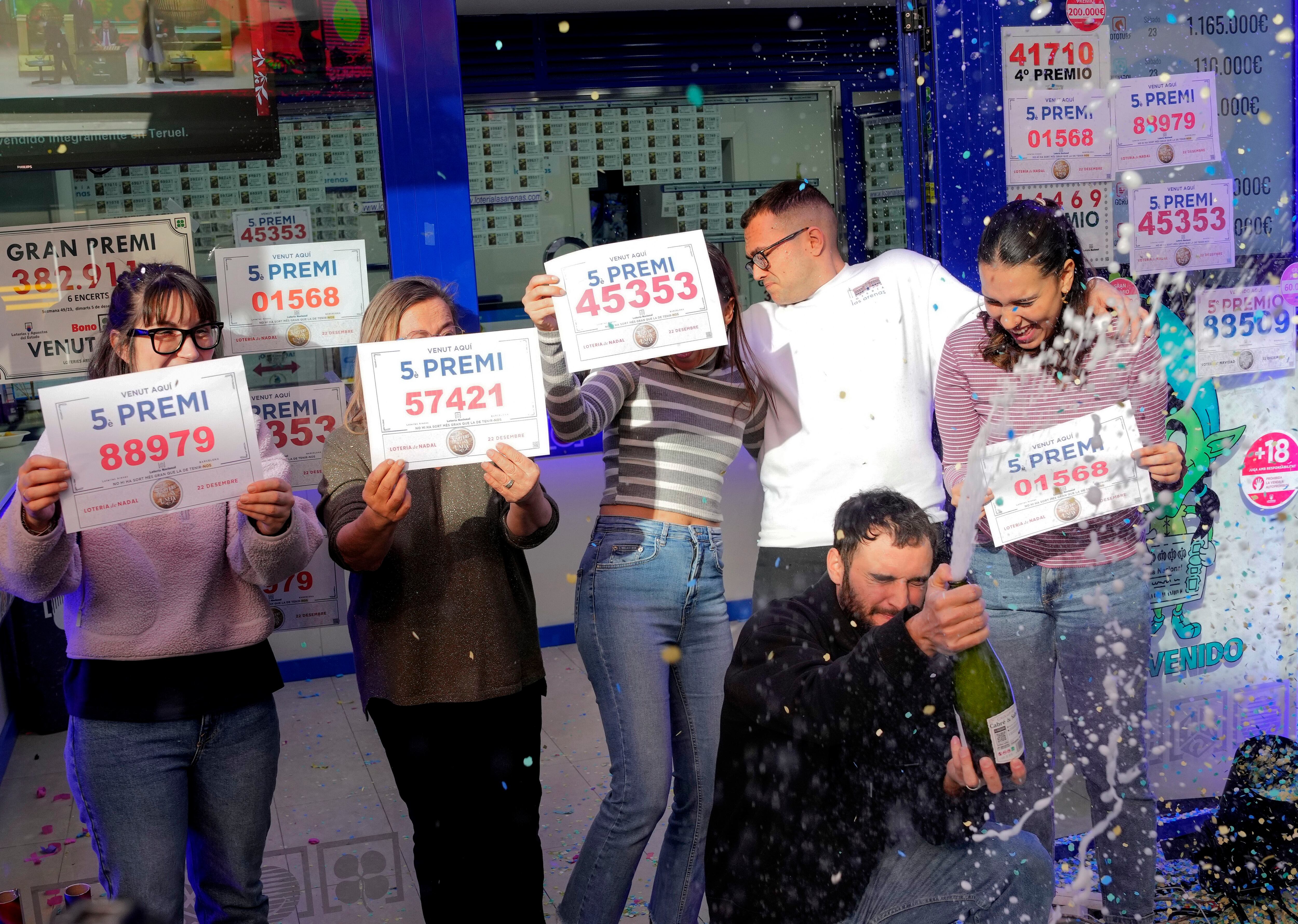 Los propietarios y trabajadores de la administración de lotería Las Arenas de Barcelona, ubicada en el centro comercial del mismo nombre, celebran haber repartido décimos de cuatro distintos quintos premios del sorteo de la Lotería de Navidad.
